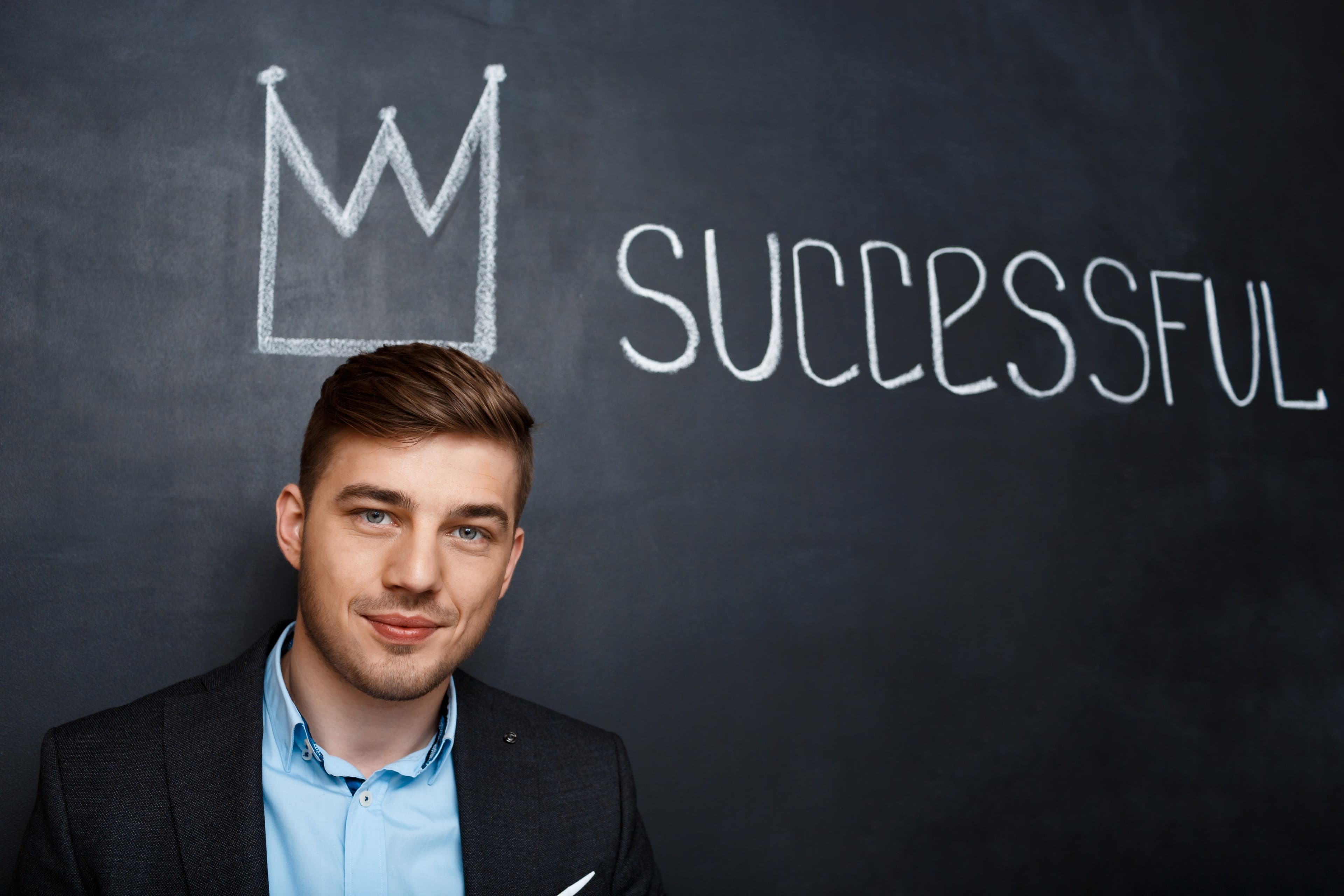 Man crown on head with blackboard written successful